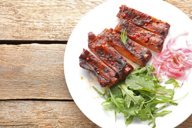 Lezzetli pirzola, soğan ve roka, ahşap masa, üst manzara. Metin için boşluk