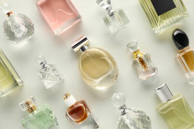 Hafif arka planda çeşitli parfüm şişeleri, düz yatıyordu.