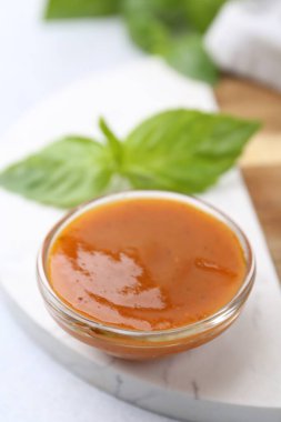 Cam kasede lezzetli köri sosu ve beyaz masada fesleğen, yakın plan.