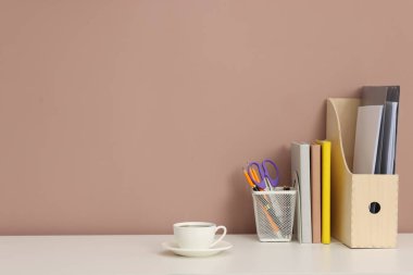 Beyaz ofis masasında farklı kırtasiye ve kahve, koyu bej arka plan, metin için yer