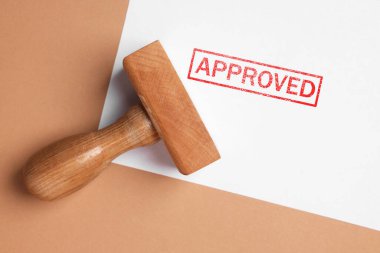 Sözcükle onaylanmış kağıt yaprağı ve bej arka plan, üst görünüm üzerine damga