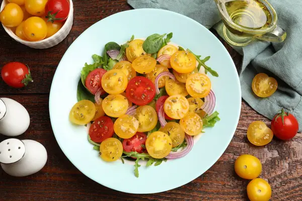 Tahta masada servis edilen sarı domatesli taze salata.