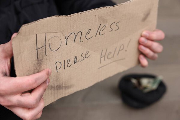Man with sign Homeless please help outdoors, closeup