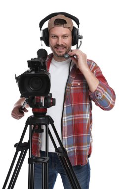 Profesyonel kameralı ve kulaklıklı bir adam beyaz arka planda.