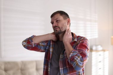 Evde boynu ağrıyan bir adam var.