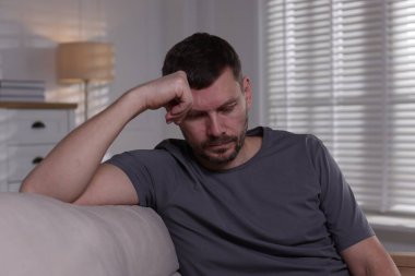 Evdeki kanepede depresif bir adam. Zihinsel sağlık sorunu