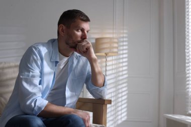 Evdeki kanepede depresif bir adam, mesaj için yer var.