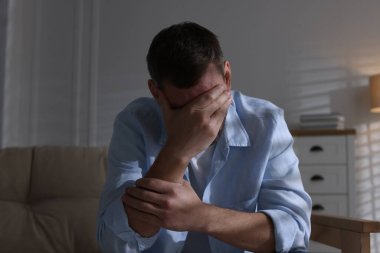 Evdeki kanepede depresif bir adam. Zihinsel sağlık sorunu