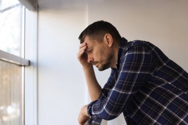 Binanın penceresinin yanında depresif bir adam var. Zihinsel sağlık sorunu