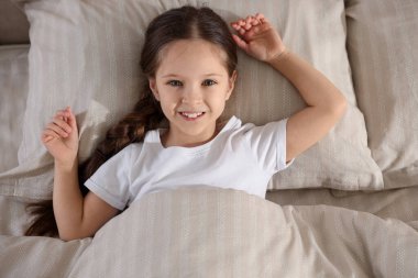 Yatakta uzanmış tatlı bir kız, yukarıda.