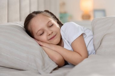 Evde yatakta uyuyan tatlı bir kız.