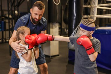 Boks koçu spor merkezinde çocukları eğitiyor.