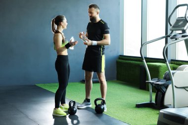 Spor salonunda su şişesi ve su ısıtıcısı olan çift.
