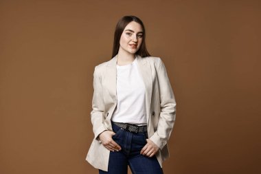 Kahverengi arka planda şık kotlu güzel bir kadın.