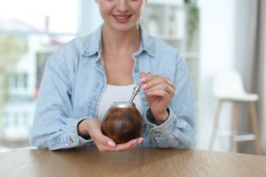 Kapalı mekândaki masada geleneksel çay eşliğinde bir kadın, yakın plan. Metin için boşluk