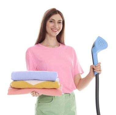 Buharlı gülen kadın ve beyaz arka planda bir yığın kıyafet.