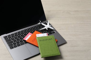 Pasaportlar, uçuş biletleri, uçak modeli ve dizüstü bilgisayar ahşap masa, mesaj için yer