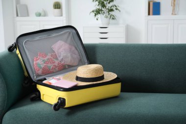 İçinde farklı giysiler ve pasaport olan bavulu aç.