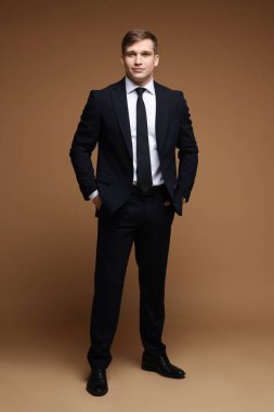 Kahverengi arka planda klasik takım elbiseli adam.