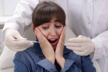 Klinikte dişçiyle randevusu olan korkmuş bir kadın.