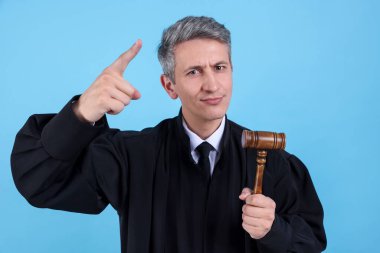 Açık mavi arka planda tokmağı olan duygusal yargıç.