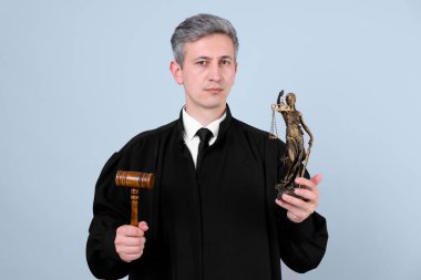 Gri arka planda Adalet Anıtı heykeli ve tokmakla hakim