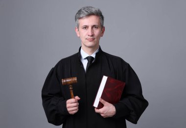 Gri arkaplan üzerine kitap ve çekiçle yargıç