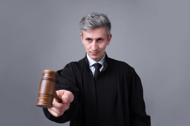 Gri arkaplanda çekiçli yargıç portresi