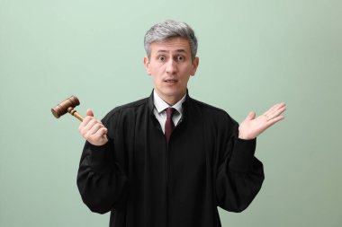 Yeşil arka planda tokmağı olan duygusal yargıç.