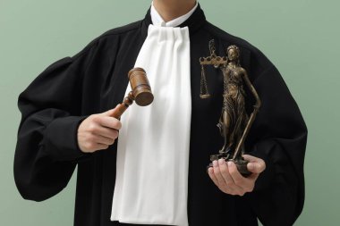 Açık yeşil arka planda Adalet Anıtı 'nın çekici ve figürlü hâkimi, yakın plan.