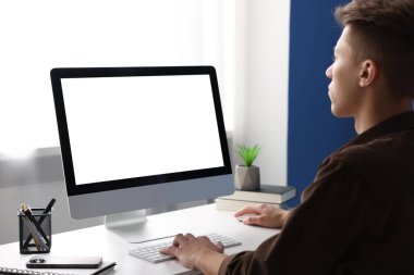 Ofisteki beyaz masada bilgisayarda çalışan bir adam. Tasarım için model