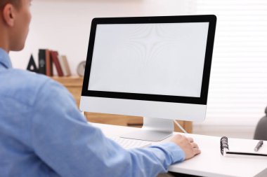 Ofisteki beyaz masada bilgisayarda çalışan bir adam, yakın plan. Tasarım için model