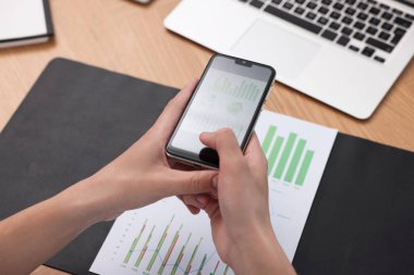 Ofisteki masada akıllı telefondan tarama uygulaması kullanarak belgenin fotoğrafını çeken adam, yakın plan.