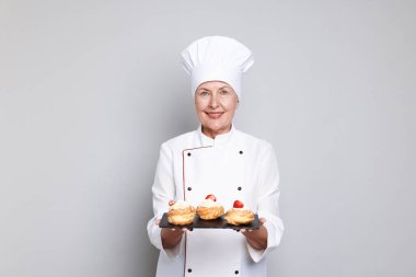 Açık gri arka planı olan profesyonel pasta şefi.