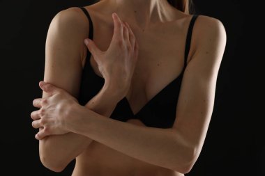 Siyah arka planda sutyen giyen kadın, yakın plan.