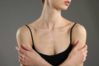 Gri arka planda mükemmel bir teni olan kadın, yakın plan.