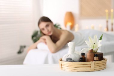 Kadın kuaförde dinleniyor, spa ürünlerine ve çiçeklere odaklanıyor