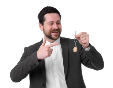 Beyaz arka planda ev şekilli anahtarlığı olan bir emlakçı.