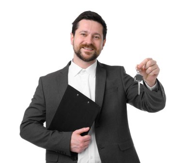 Emlakçının elinde anahtarlık, ev şeklindeki anahtarlık ve beyaz arka planda pano var.