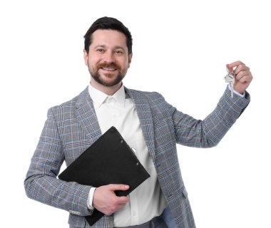 Emlakçının elinde anahtarlık, ev şeklindeki anahtarlık ve beyaz arka planda pano var.