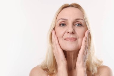 Beyaz arka planda orta yaşlı güzel bir kadının portresi. Metin için boşluk