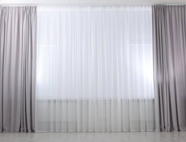 Açık gri pencere perdeleri ve beyaz tüller.