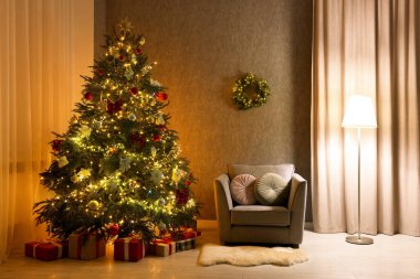Güzel bir Noel ağacı, koltuk ve lambası olan rahat bir oda. Tatil için iç tasarım
