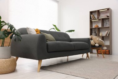 Rahat kanepesi ve ahşap raf ünitesi olan şık bir oturma odası. İç tasarım