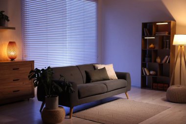 Rahat kanepesi ve ahşap raf ünitesi olan şık bir oturma odası. İç tasarım