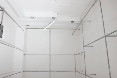 Boş yenileme odasındaki beyaz duvarların yakınındaki metal borular.