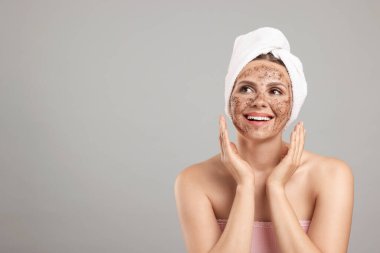 Yüzünde gri bir arka plan olan gülümseyen bir kadın. Metin için boşluk