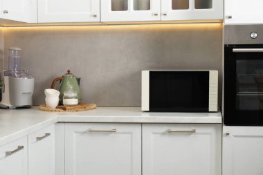 Mutfak tezgahında kapalı mikrodalga fırın.