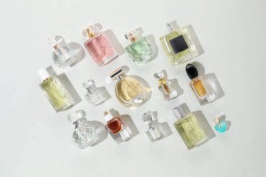 Hafif arka planda çeşitli parfüm şişeleri, düz yatıyordu.