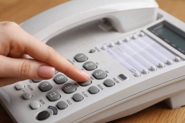 Ahşap masada telefonla arayan kadın, yakın plan.